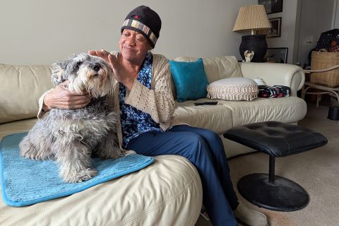 Tonya McCoy sits with a dog on a couch. 