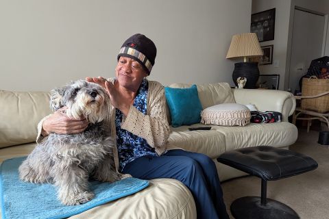 Tonya McCoy sits with a dog on a couch. 