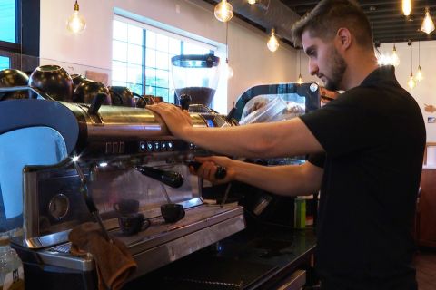 Man makes coffee in a shop
