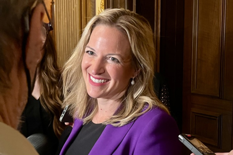 Secretary of State Jocelyn Benson wears a purple blazer.
