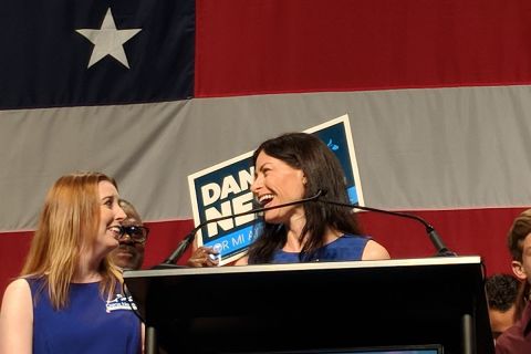 Attorney General Dana Nessel is on a stage next to her wife, Alanna Maguire.