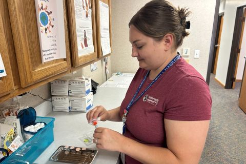 A nurse works with medical equipment in a clinic