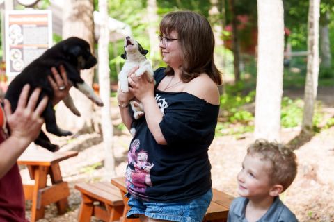 People smile as they hold puppies