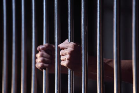 A prisoner gripping prison bars