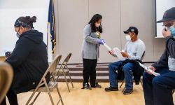 Claudia Pohlen of the Hispanic Center of Western Michigan passes out information about Michigan’s redistricting process during a COVID-19 vaccination clinic this month in Wyoming. 