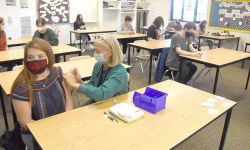 Annelle Kastor, a public health nurse with the Grand Traverse County Health Department, administers a Covid-19 vaccine to Alexis Sattler, 16, at Kingsley High School Thursday