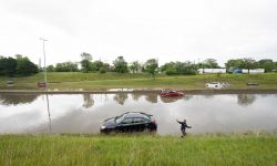 A Detroit child plays near a car on a flooded freeway June 26 after a storm left thousands of Detroiters with destroyed property and flooded basements