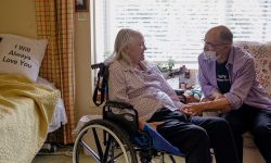 Jim Mangi, 73, reaches out to his wife Kathleen Schmidt’s, 72, at Brecon Village Memory Support Center in Saline. 