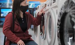 woman in mask looking at washer