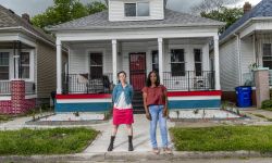 two woman in front of a house