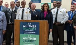 whitmer standing by a lot of law enforcement officers