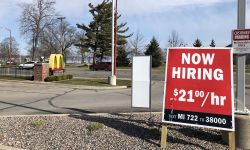 a sign outside of mcdonalds, advertising a wage of 21 an hour