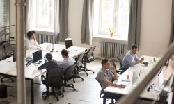 Top view of diverse people working together on computer performing daily routine tasks in coworking space, multiracial millennial men and women busy using devices discussing projects in shared office