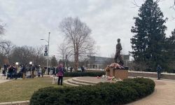 people gather around the Spartan statue 