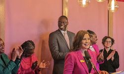 Gov. Gretchen Whitmer at a press conference surrounded by people clapping