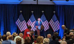 Florida Gov. Ron DeSantis on stage with a hall full of people