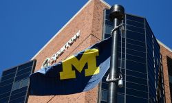 University of Michigan flag in front of Sparrow Health System hospital