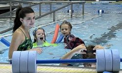 an adult and children in a pool