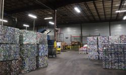 barrels of Aluminum cans and bottles pressed into bricks in a warehouse