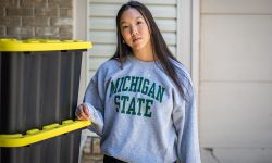 Sophia Yee standing next to boxes