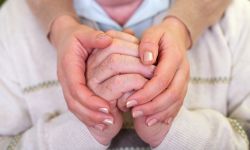 Close up picture of elderly hands with young caretaker's hands