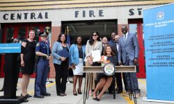 Michigan lawmakers smile in front of fire station