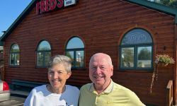 Kathy Bair and Ed Roginski standing in front of Fred’s 