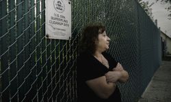 Carol Garza leans against the fence