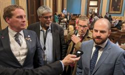 group of lawmakers talking into a microphone