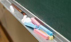 Closeup of blank green blackboard with pieces of chalks