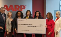 Gov. Gretchen Whitmer holding check