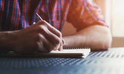 man writing in a notebook