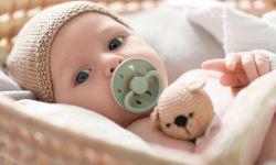  Cute newborn baby on white blanket in wicker crib, closeup