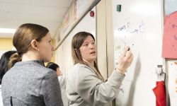 Boulan Park Middle School math teacher Jordan Baines writing on whiteboard