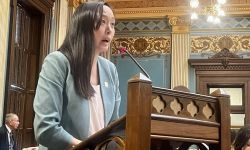 Sen. Stephanie Chang, D-Detroit, standing at a podium in the Michigan Legislature