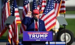 Trump campaigning in Michigan, wearing a blue suit and MAGA hat