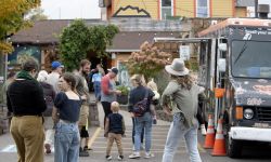 People standing in a parking lot, next to a food truck in Marquette, Mich