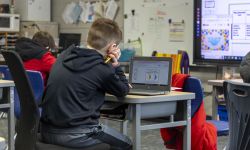 A student looking at this laptop in a classroom. 