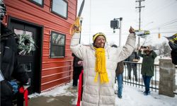 Woman cuts the ribbon on housing project