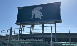 A green Spartan scoreboard on a sunny day. 