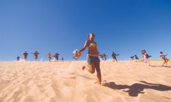 People run down a sandy dune at Sleeping Bear Dunes National Lakeshore