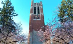 Beaumont Tower, symbol of Michigan State University, in early spring. Blue cloudless sky, pink cherries about to bloom. 