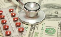 Stethoscope on money background and pills.
