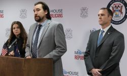Michigan Rep. Brad Paquette is at a podium. Sen. Thomas Albert stands behind him.
