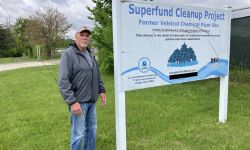 Man stands by sign