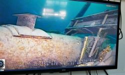 A photo of the Line 5 pipeline on a TV screen. You can see the pipeline is in open water.