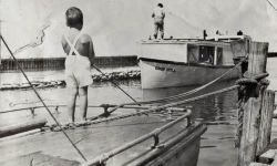 A historical photo of two boys fishing. 