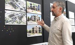 A man looks at building plans pinned up on a wall