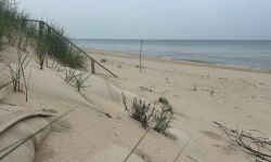 A sandy dune is seen in the foreground with Lake Michigan beyond