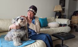 Tonya McCoy sits with a dog on a couch. 